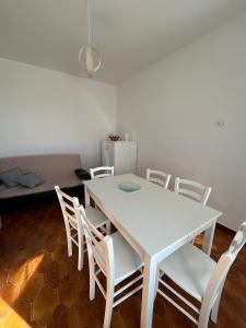 a white table and chairs in a room with a couch at Casa Vacanze Anema & Core in Agerola +12 photos