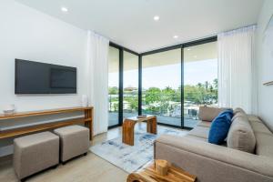 a living room with a couch and a flat screen tv at Mono Luxe Villas in Tamarindo