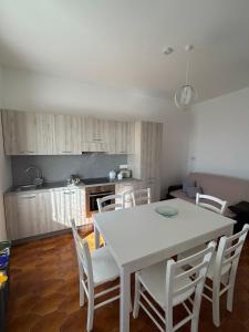 a kitchen with a white table and white chairs at Casa Vacanze Anema & Core in Agerola