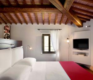 a bedroom with a white bed and a tv at Poggio Piglia in Chiusi