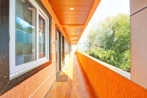an orange corridor of a building with windows at Hotel O Tanatan Premium in Bhopal
