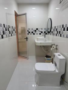 a white bathroom with a toilet and a sink at Vegas Luxe Thoddoo in Thoddoo