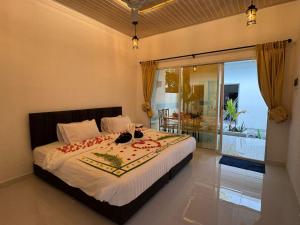 a bedroom with a bed with a view of a balcony at Vegas Luxe Thoddoo in Thoddoo