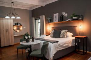 a bedroom with a bed with a table and chairs at Stay Local Potchefstroom in Potchefstroom