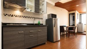 a kitchen with a refrigerator and a table with chairs at Apartamentos CasaMJ Tunja Confort y Parqueadero in Tunja