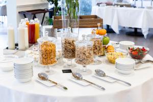 a table with jars of food and plates and spoons at Hotel Don Ferrante in Bellagio