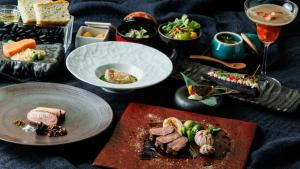 a table with plates of food and a glass of wine at 奈良春日 鹿のや in Nara