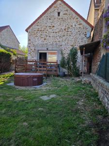 a backyard with a wooden fence and a building at La liberté des trois petits cochons avec spa in Lalizolle