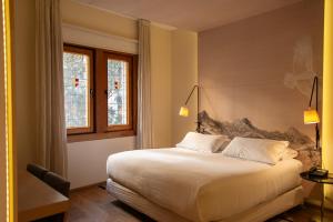 a bedroom with a large white bed and two windows at Hotel Magnolia Santiago in Santiago