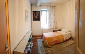 a small bedroom with a bed and a window at Maison de village commingeoise in Miramont-de-Comminges