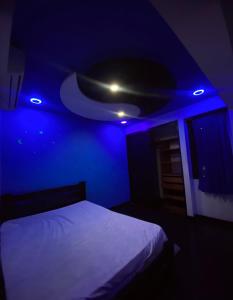 a dark room with a bed with a blue light at Casa Cristian in Caracas