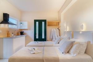 two beds in a room with a kitchen at Vasiliki Petri Olive House in Petra