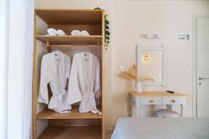 a bedroom with a closet with white clothes and a bed at Vasiliki Petri Olive House in Petra +19 photos