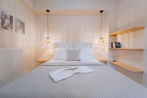 a bedroom with a white bed with two towels on it at Vasiliki Petri Olive House in Petra