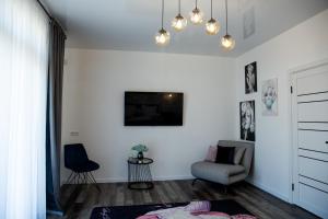 a living room with a couch and a chair at Sunday Caprice in Sanzhiyka