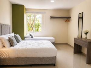 a bedroom with two beds and a window at Fuscaldo Hotel in Valledupar +13 photos