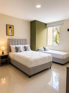 a bedroom with two beds and a window at Fuscaldo Hotel in Valledupar