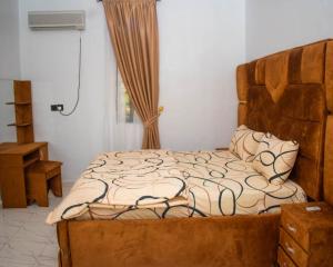 a bedroom with a large bed with a wooden headboard at Isuki apartment in Benin City