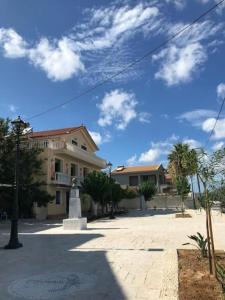 a building with a statue in the middle of a street at Karyatis studios lixouri in Lixouri