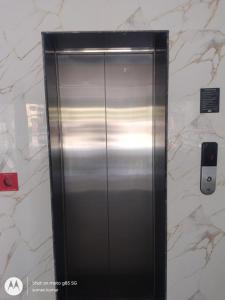 a stainless steel elevator in a marble wall at Chouhan Resort in Katihār