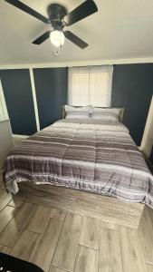 a bedroom with a bed with a ceiling fan at DC lodging LLC in Tampa
