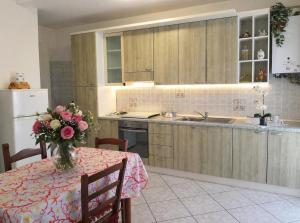 a kitchen with a table with a vase of flowers on it at Domus Sofia in Ripa Teatina