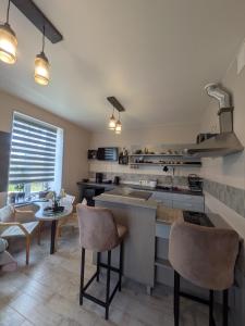 a kitchen with a counter and a table and chairs at Gala Kambaris in Myza Bene +8 photos