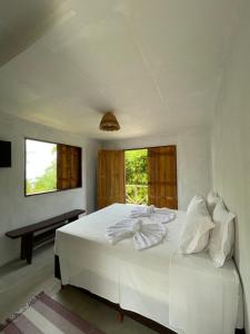 a white bed in a room with a window at Pousada Vila do Alto in Japaratinga