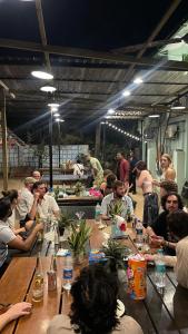 a group of people sitting at long wooden tables at The Beachside Hostel in Anjuna