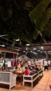 a group of people sitting at tables in a restaurant at The Beachside Hostel in Anjuna