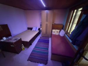 a small room with a bed and a staircase at Kazanlak SHELTER HOUSE ACCOMODATION 1 Room 1 Bed, No Water, WC is Outhouse, Dirt Road, Dog in the Garden, Genius Points Welcome! Къща за Подслон в Казанлък, Без Вода! in Kazanlŭk +4 photos
