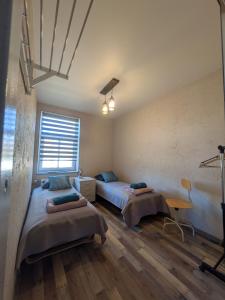 a room with two beds and a table and a window at Gala Kambaris in Myza Bene