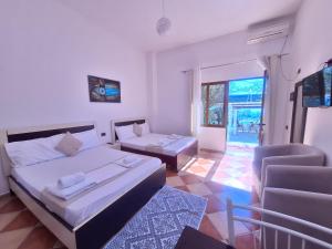 a bedroom with a bed and a couch and a chair at Mermaid Hotel Vlore in Vlorë