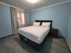 a bedroom with a large bed with white sheets and pillows at Masakwe BNB in Soweto
