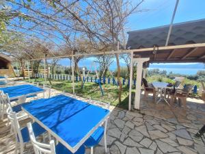 a patio with blue tables and chairs under a pergola at Mermaid Hotel Vlore in Vlorë