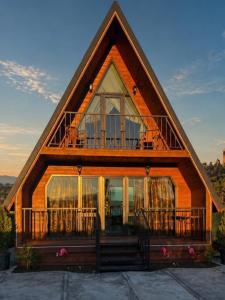 a house with a gambrel roof with a balcony at Nakas cottage in Tbilisi City