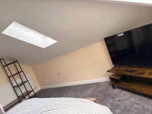 a bedroom with a flat screen tv and a bed at Easy living stays Burton on Trent in Burton upon Trent