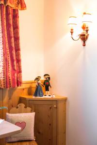 a room with a table with two dolls on it at Hotel Rochushof in Schenna