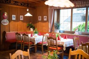 a dining room with tables and chairs in a restaurant at Hotel Rochushof in Schenna