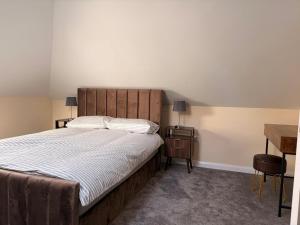 a bedroom with a large bed and a wooden headboard at Easy living stays Burton on Trent in Burton upon Trent
