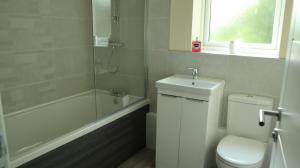 a bathroom with a toilet and a tub and a sink at Easy living stays Burton on Trent in Burton upon Trent