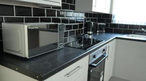 a kitchen with a microwave on a black counter top at Easy living stays Burton on Trent in Burton upon Trent