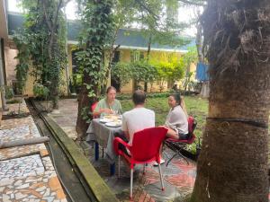 a group of people sitting at a table in a garden at Zebra guesthouse Hawassa in Āwasa