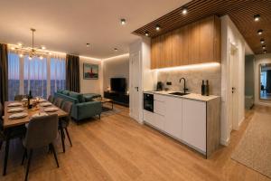 a kitchen and living room with a table and a dining room at Apartamentai Palangoje Arune in Palanga