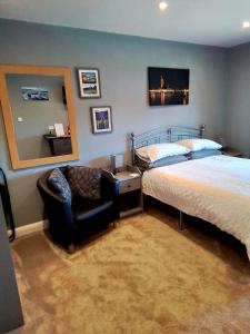 a bedroom with a bed and a chair in it at Large double room with spacious ensuite in Southbourne