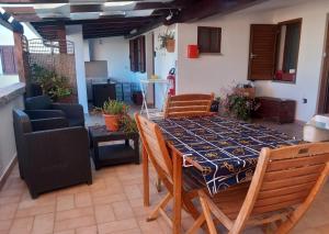 a dining table and chairs in a living room at B&B Feronia in Posada