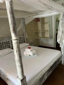 a bed with a stuffed elephant and towels on it at Studio Leliya in Malindi +14 photos