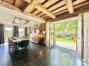 a kitchen with a table and a large sliding glass door at Le Grenier de Louise in Gimnée