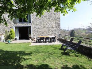 a house with a table and chairs in the yard at Le Grenier de Louise in Gimnée