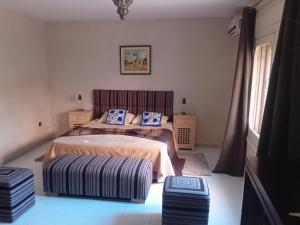 a bedroom with two beds and a chair in it at Le havre de paix in Marrakesh